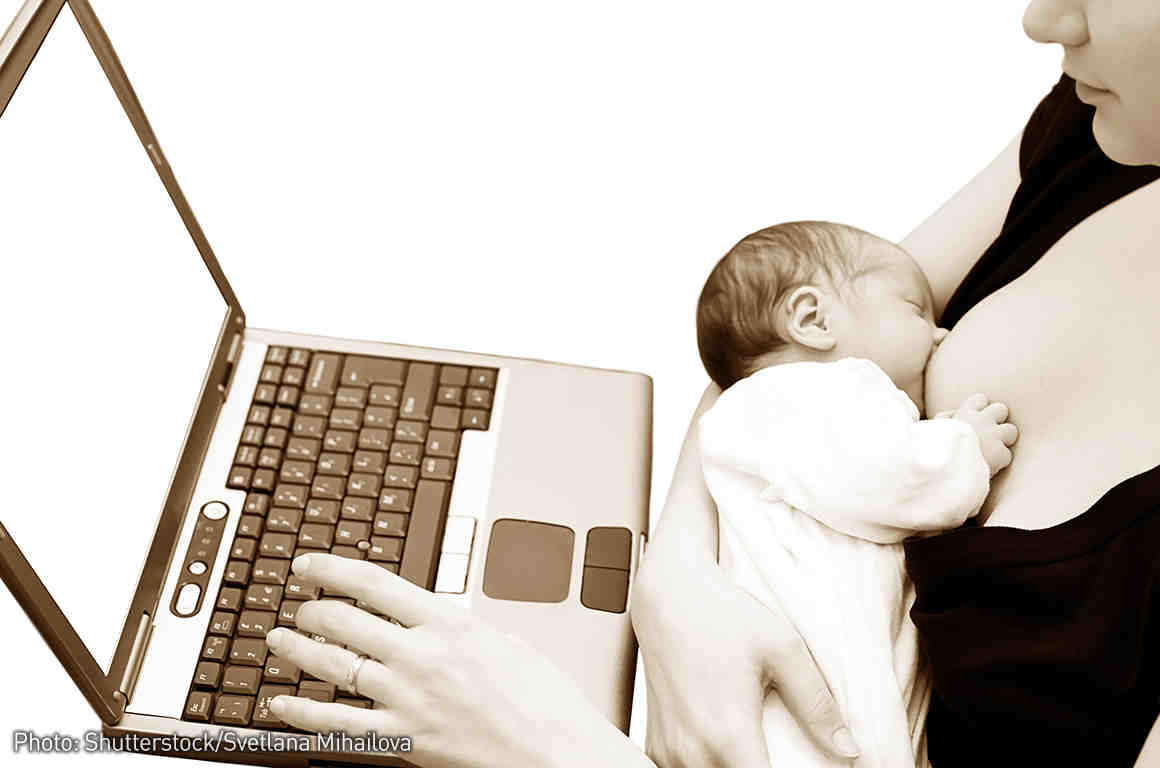 Breastfeeding baby with mom at the laptop