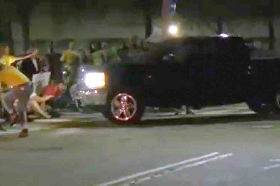 Protesters blocking an entrance to the Donald W. Wyatt Detention Facility begin to move as a pickup truck approaches