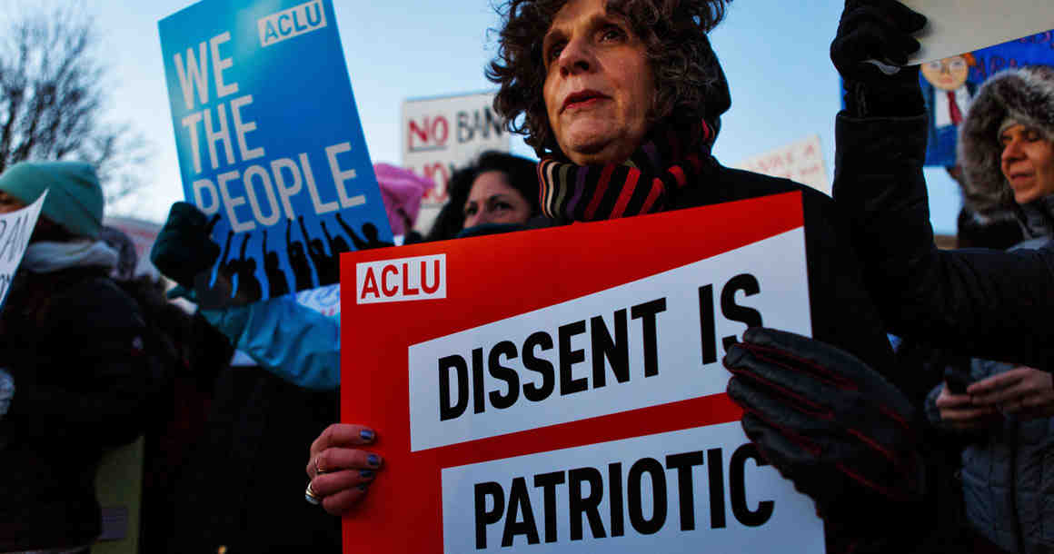 Protester holding "Dissent is Patriotic" Sign