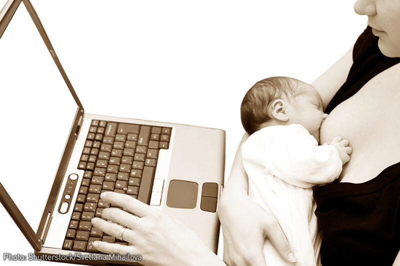 Breastfeeding baby with mom at the laptop