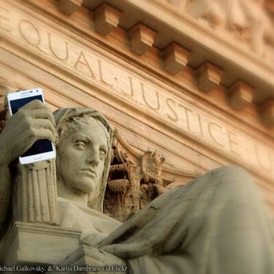 Justice figure statue holding cell phone