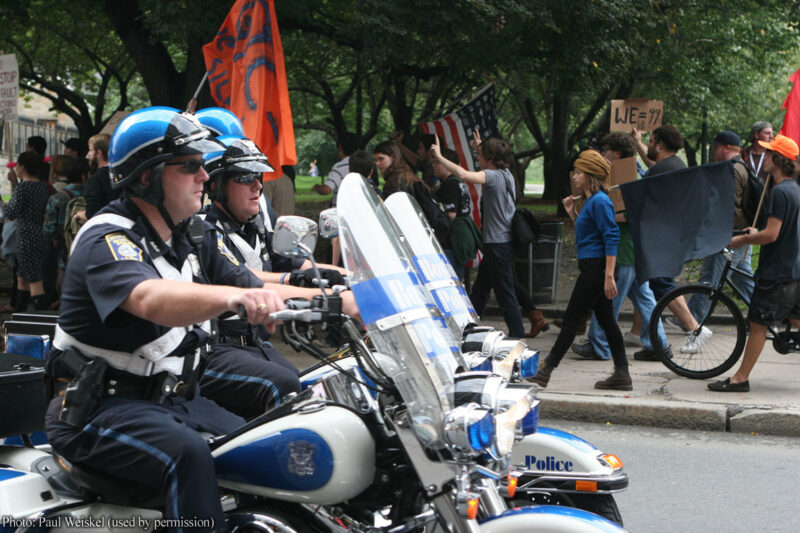 Police on motorcycles in front of protesters