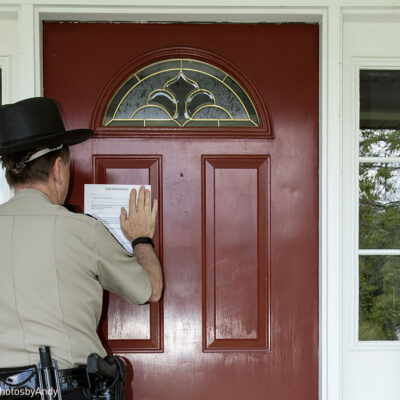 Law enforcement officer posting an eviction notice