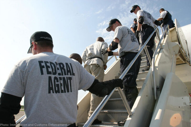 Federal agents deporting individuals on a plane