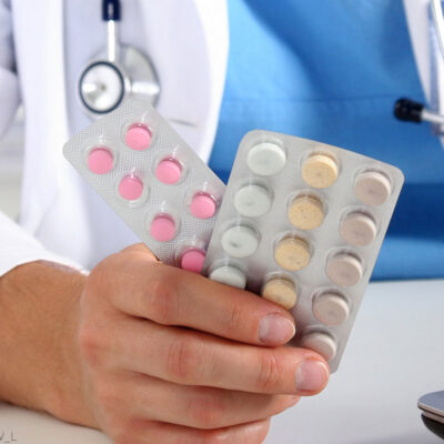 Pharmacist holding pack of birth control pills