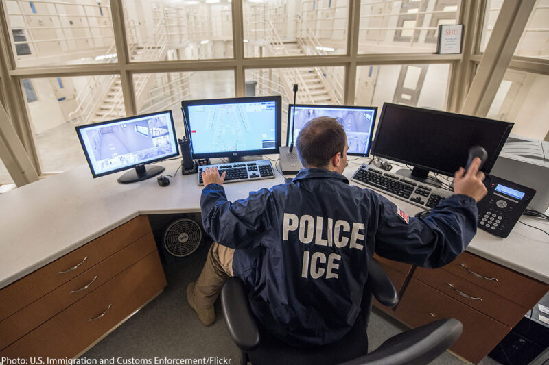 ICE officer looking at computer screens