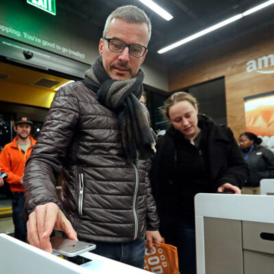 A customer scanning the Amazon Go cellphone app at the entrance of an Amazon Go store