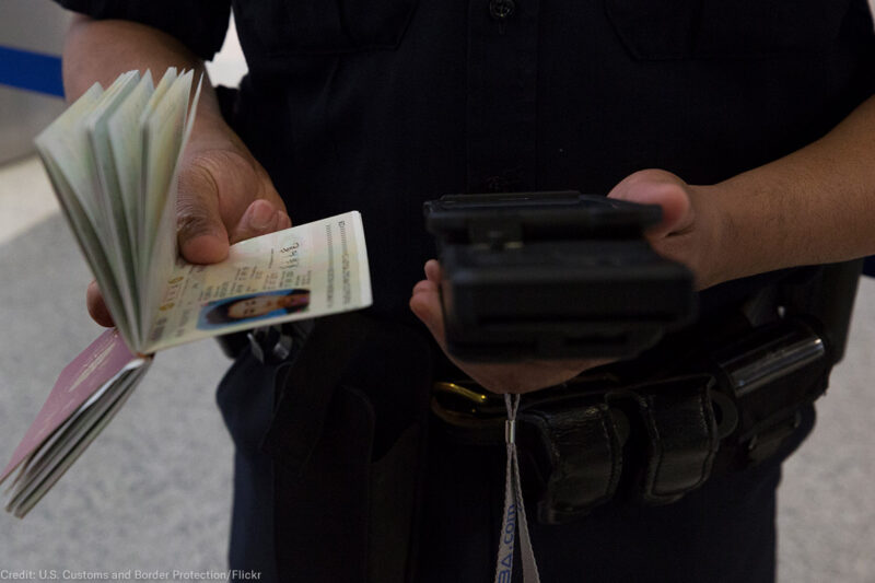 A CBP officer checks a passenger's ID