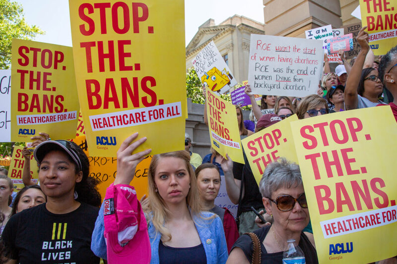 Demonstrators carrying signs in favor of stopping the abortion bans