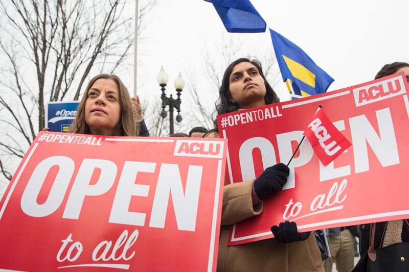 Demonstrators holding signs with the message 'Open to All"