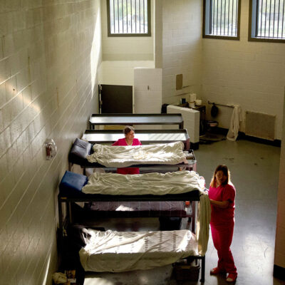 Women standing by bunk in jail cell