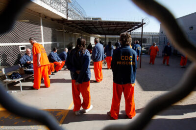 Inmates walk around a recreation yard of a California prison.