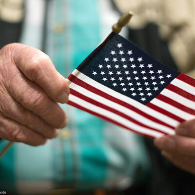 A man holding the American flag after a naturalization ceremony.