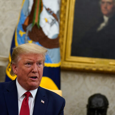 Donald Trump speaking in the Oval Office with a painting of George Washington in the background.