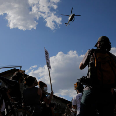 Protestors react to a low flying helicopter during a march in Brooklyn, New York.