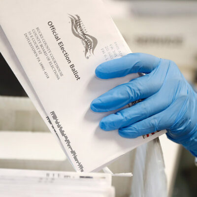 A worker processes mail-in ballots.