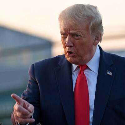 Trump wags finger as he talks to reporters before departing from a New Jersey airport.