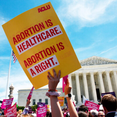 Pro-abortion activist holds ACLU placard that reads "Abortion is healthcare. Abortion is a right." during a rally at the Supreme Court