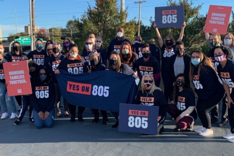 A group of people wearing shirts and carrying banners that read "Yes on 805" referring to Oklahoma's Question 805 on the ballot.