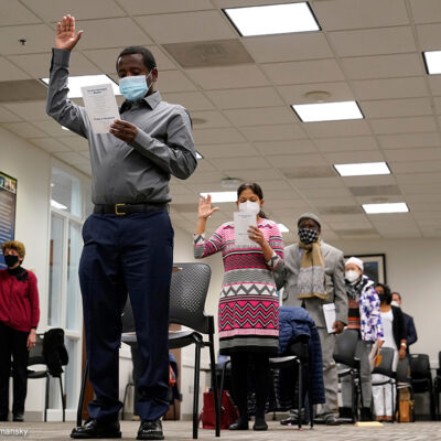 Candidates for American citizenship recite the Oath of Allegiance during a naturalization ceremony.