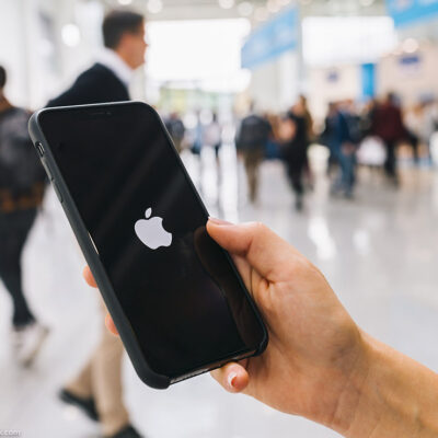 Person holding iPhone with Apple logo on screen