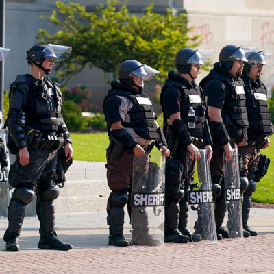 Police in riot gear stand outside the Kenosha County Court House