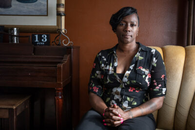 A portrait of Crystal Mason sitting in a chair next to a piano.