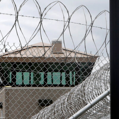 A guard tower over the fence at a correctional health care facility.