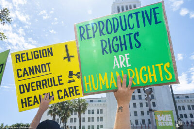 Two protestors at a pro-abortion march holding signs reading 