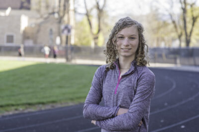 Photo of Lindsay Hexoc, a white woman with blonde hair in exercise clothing standing on a track