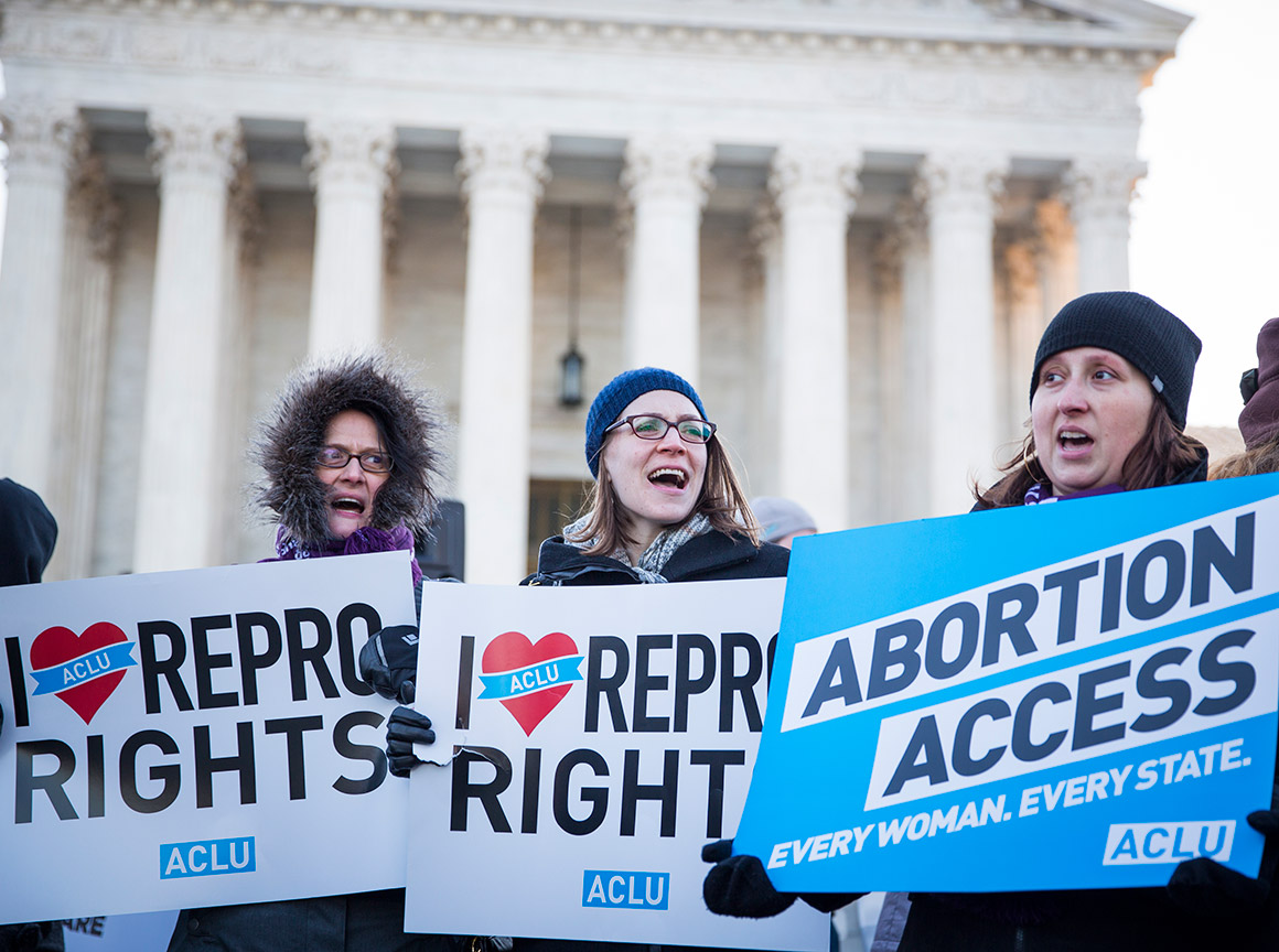 "Abortion Access" and "I heart Repro Rights" signs in front of Supreme Court