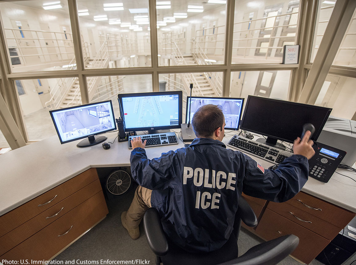 ICE officer looking at computer screens