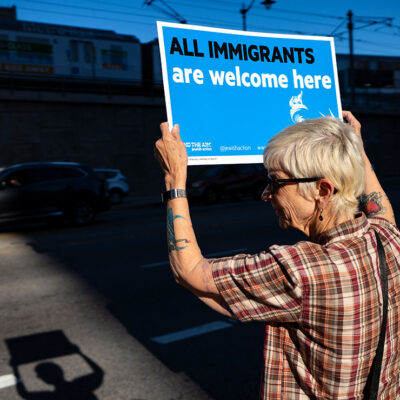 Protester holds a sign that says All Immigrants are Welcome Here.