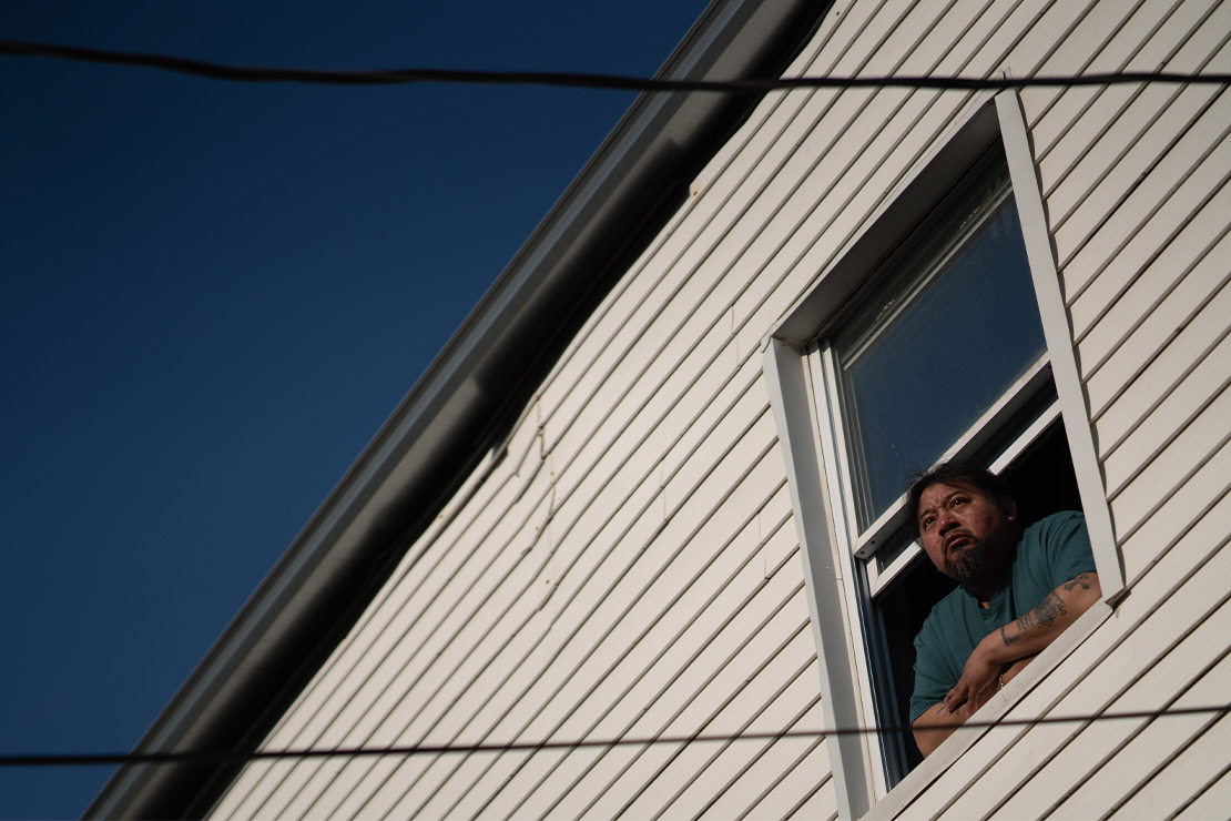 Margarito keeping a watchful eye from a window in his house.