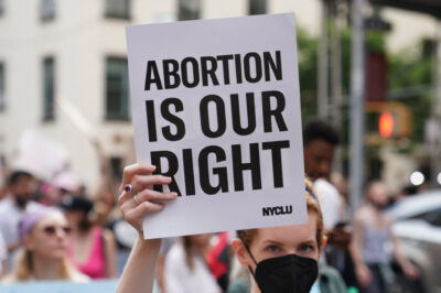 A demonstrator holding a sign that says Abortion is Our Right.