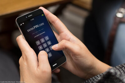 A person trying to enter security pin code on a cell phone screen.