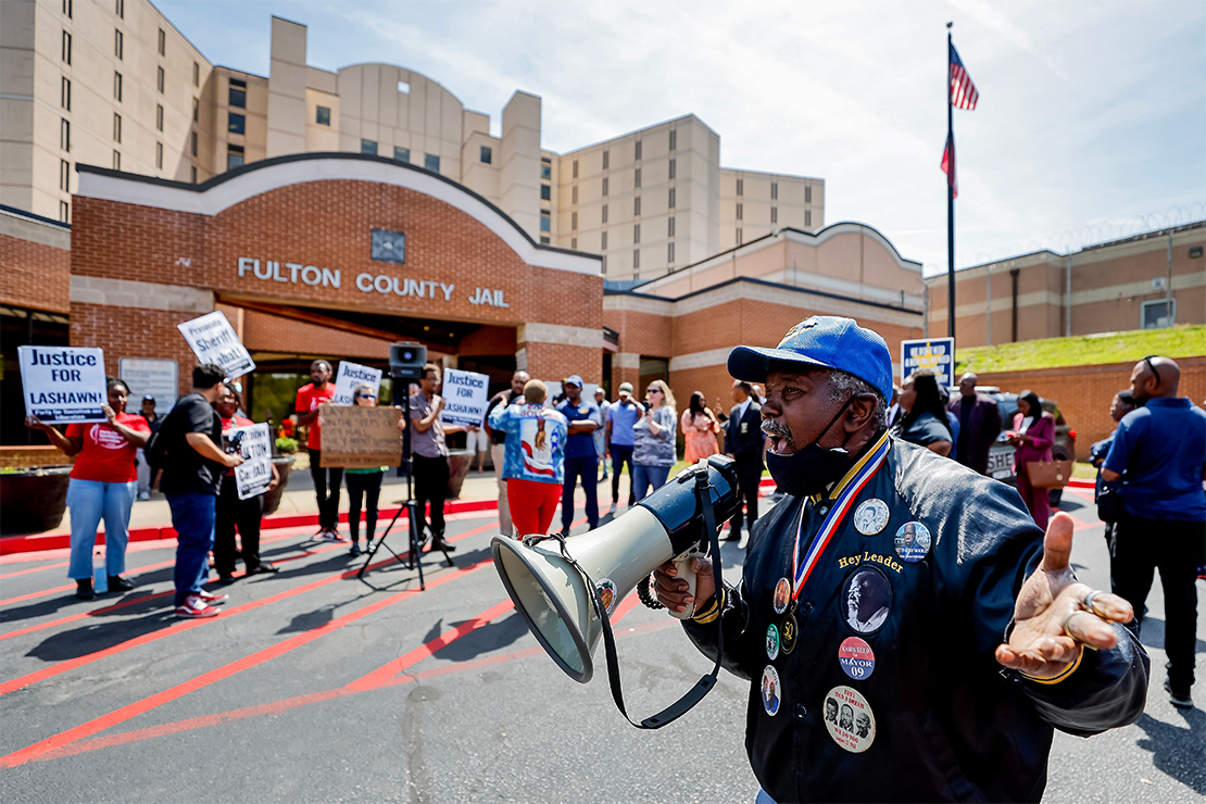 Protestor yelling through bullhorn at march at Fulton County Jail after the death of Lashawn Thompson.