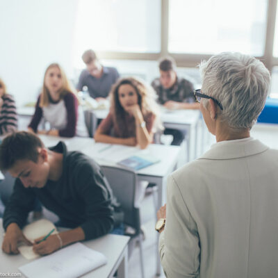 A professor in front of a class full of students.