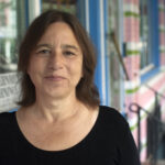 Headshot of writer Sarah Schulman smiling closed-mouth.