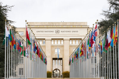 International flags flying in front of the Geneva office of the United Nations.