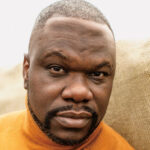 Headshot of poet and activist Ian Manuel with a neutral expression.