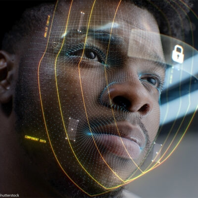 A closeup of a young African American man whose face is being scanned by facial recognition software.